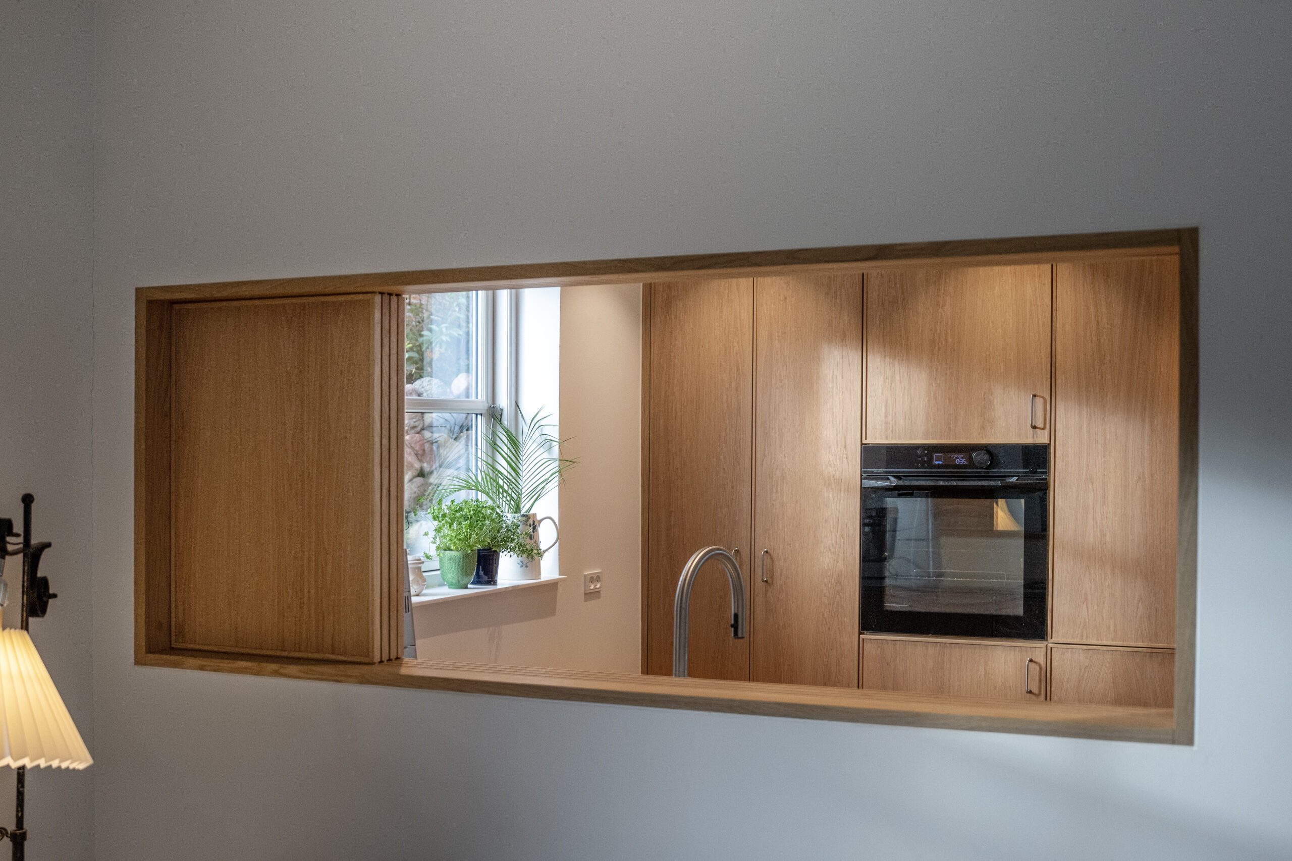 Modernt køkken med indbyggede skabe og ovn, designet af Signatur Snedkeri.