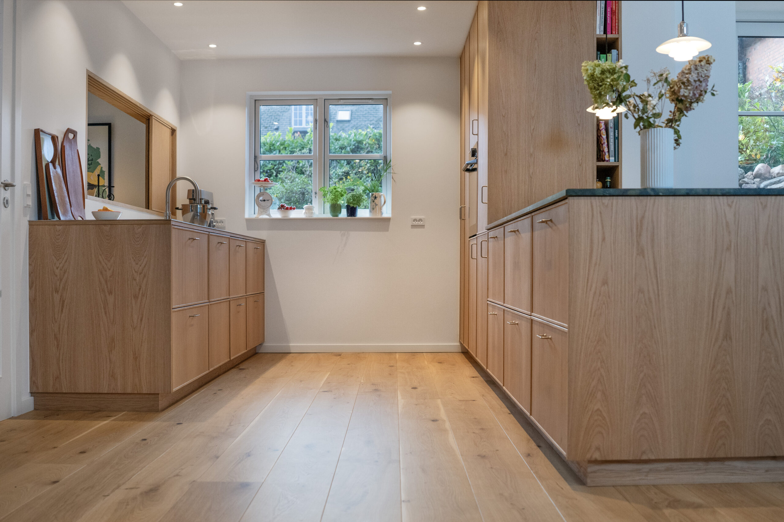 Billede af moderne køkkenudformning i træmateriale med naturskønne detaljer.