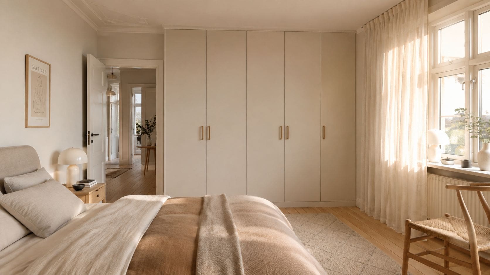 Lyst soveværelse med beige garderobeskabe, en behagelig seng og blødt dagslys fra vinduet i skandinavisk stil.